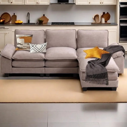 Canapé trois places capitonné beige avec assises et coussins profonds